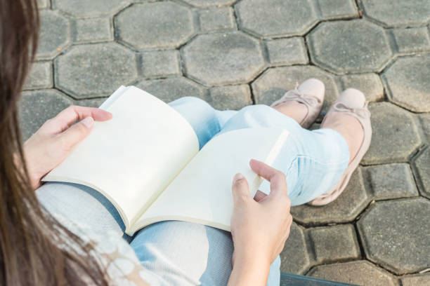 Woman sitting in the public park for reading a book joven sentada leyendo-ars poética